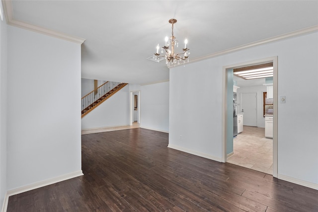 empty room featuring crown molding, a chandelier, and hardwood / wood-style flooring