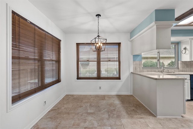 unfurnished dining area featuring a chandelier and sink