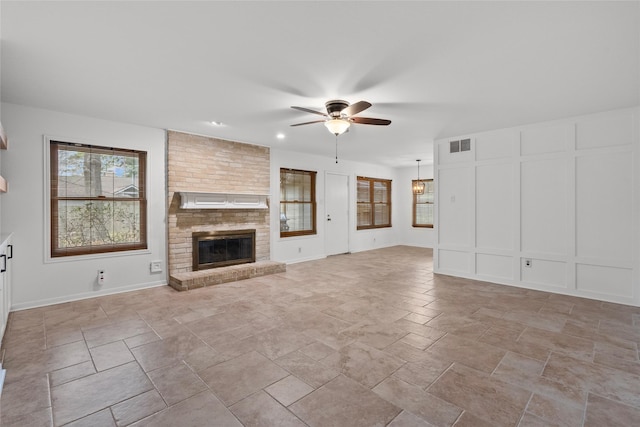 unfurnished living room with a brick fireplace and ceiling fan