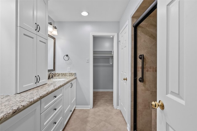 bathroom with tile patterned flooring, vanity, and a shower with shower door