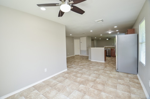 unfurnished living room with ceiling fan and a healthy amount of sunlight