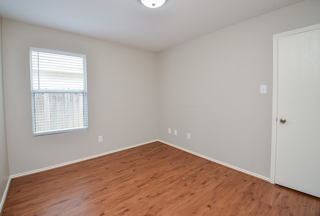 empty room with baseboards and wood finished floors