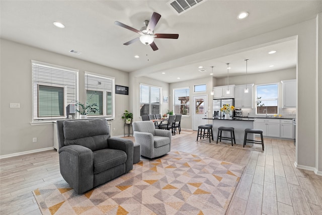 living room featuring light wood-type flooring and ceiling fan