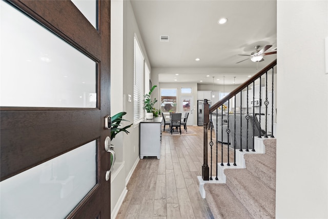 foyer with light hardwood / wood-style flooring and ceiling fan