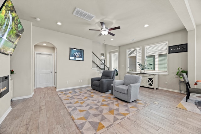 living room with ceiling fan and light wood-type flooring