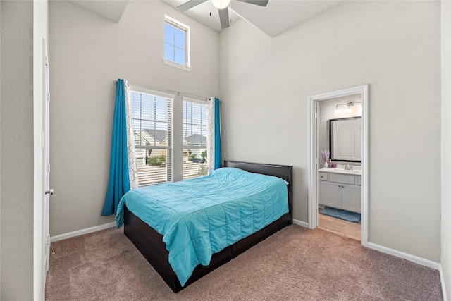 carpeted bedroom featuring connected bathroom, a high ceiling, and ceiling fan