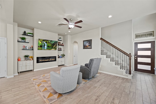 living room featuring ceiling fan and light hardwood / wood-style flooring