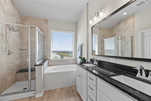 bathroom with shower with separate bathtub, wood-type flooring, lofted ceiling, and vanity