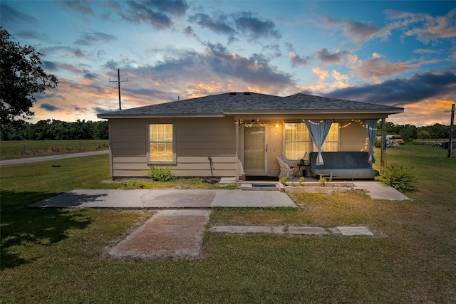 view of front of property featuring covered porch and a lawn