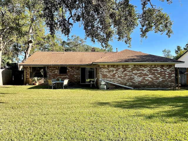 rear view of property featuring a lawn