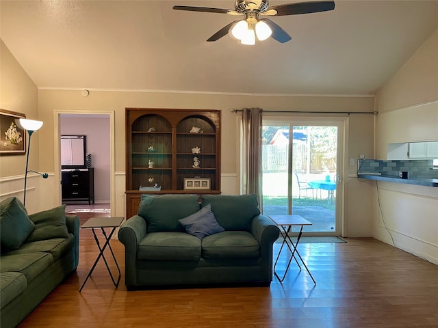 living room featuring hardwood / wood-style flooring, ceiling fan, and vaulted ceiling