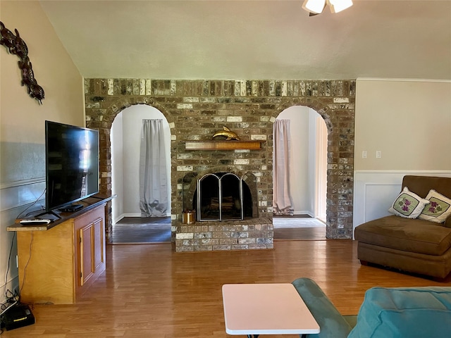 living room with hardwood / wood-style floors and a brick fireplace