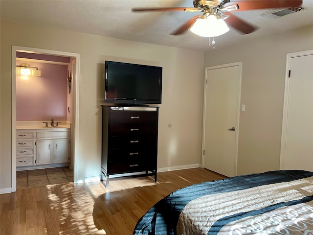 bedroom with sink, a textured ceiling, light hardwood / wood-style floors, and ceiling fan