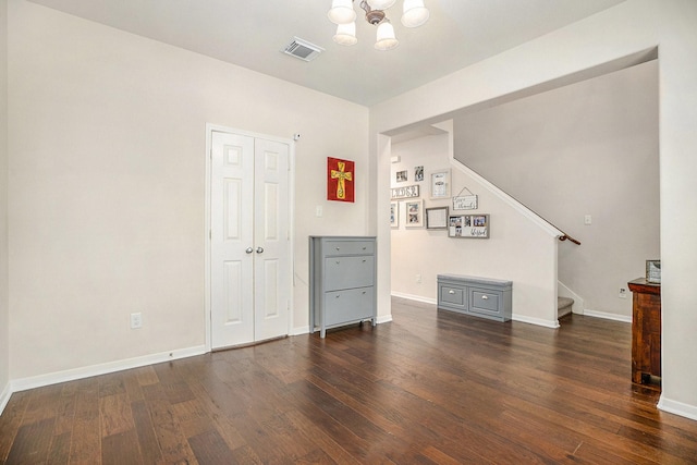 interior space featuring dark wood-type flooring and a notable chandelier