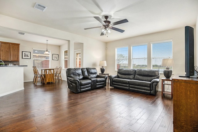 living room with ceiling fan and dark wood-type flooring