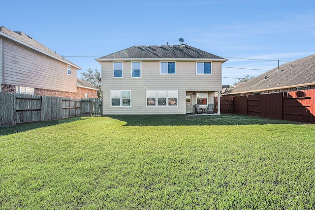 rear view of house featuring a yard