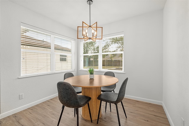 dining area with light hardwood / wood-style flooring and a chandelier