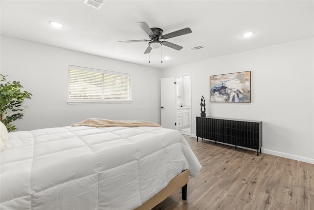 bedroom with connected bathroom, ceiling fan, and light hardwood / wood-style flooring