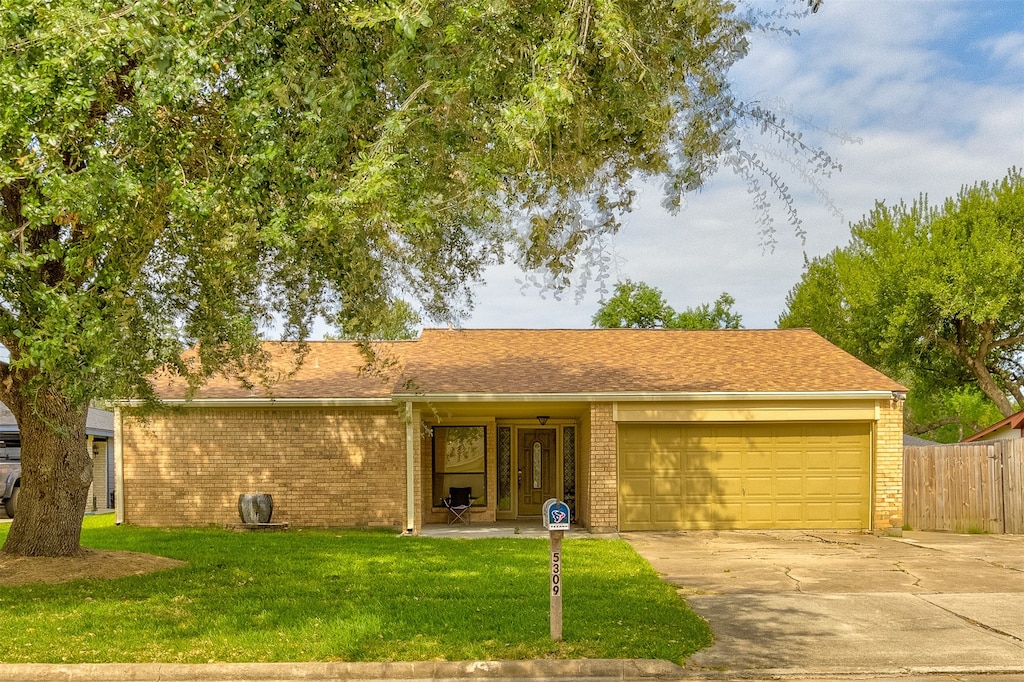 ranch-style house with a front yard and a garage