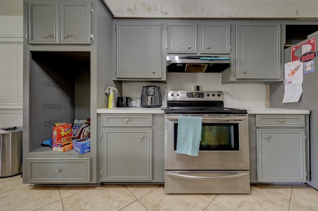 kitchen featuring gray cabinets, stainless steel electric stove, and light tile patterned floors