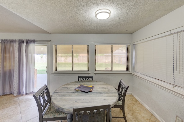 dining room featuring a textured ceiling and light tile patterned floors