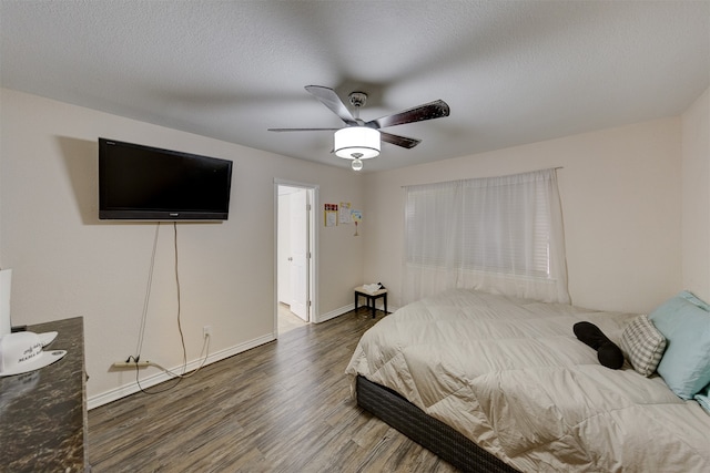 bedroom with ceiling fan, wood-type flooring, and a textured ceiling