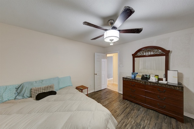 bedroom with a textured ceiling, dark hardwood / wood-style floors, and ceiling fan