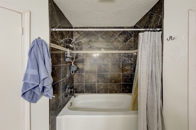 bathroom featuring shower / bath combo with shower curtain and a textured ceiling