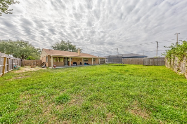 view of yard with a patio and a trampoline