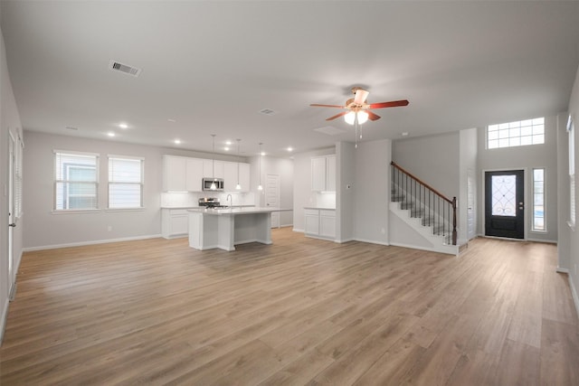 unfurnished living room with light hardwood / wood-style flooring and ceiling fan