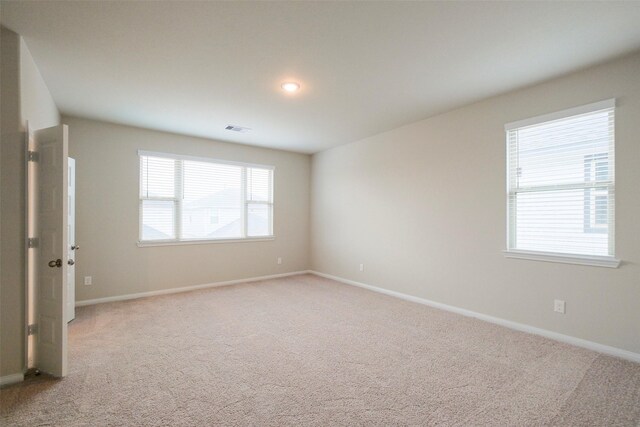 unfurnished room featuring light carpet