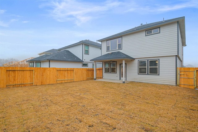 rear view of house with a patio and a yard