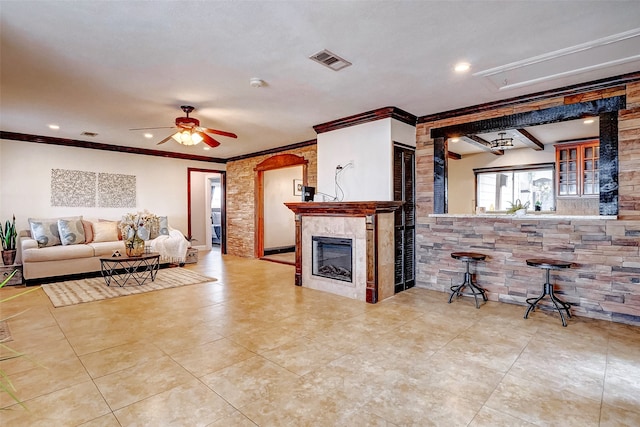 tiled living room with ceiling fan, ornamental molding, and beam ceiling