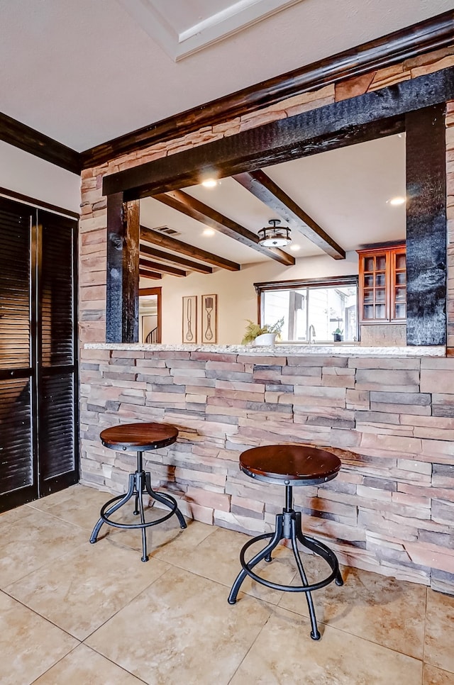 bar featuring beamed ceiling, crown molding, and light tile patterned flooring