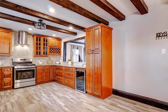 kitchen featuring stainless steel range oven, wall chimney range hood, decorative backsplash, and beverage cooler