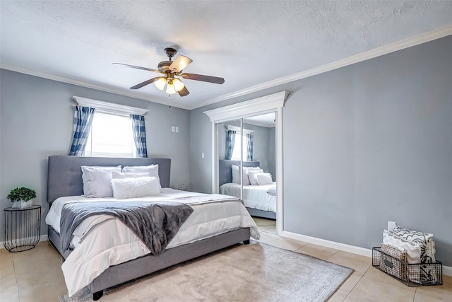 tiled bedroom with ceiling fan, a textured ceiling, and ornamental molding