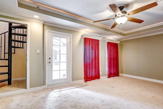 doorway to outside featuring crown molding, a raised ceiling, light colored carpet, and ceiling fan