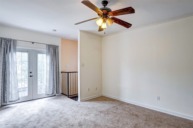 carpeted spare room featuring french doors, ornamental molding, and ceiling fan