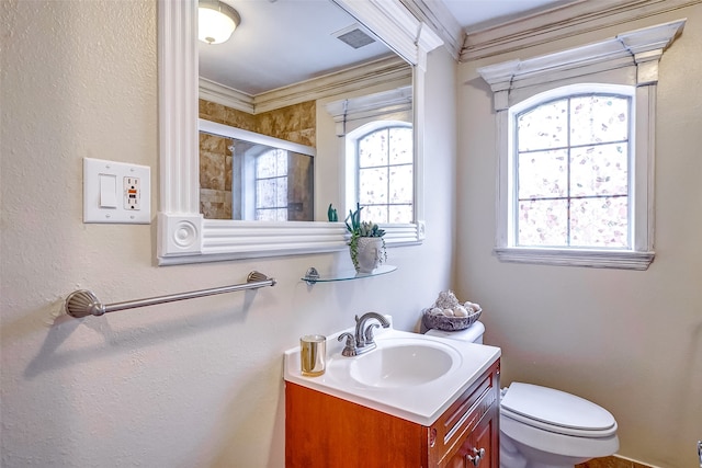 bathroom with vanity, ornamental molding, a shower with door, and toilet