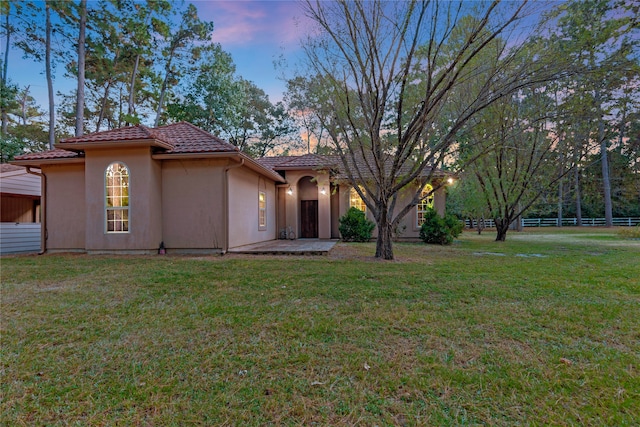 mediterranean / spanish-style house with a patio and a lawn