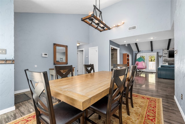 dining room featuring vaulted ceiling with beams and dark hardwood / wood-style floors