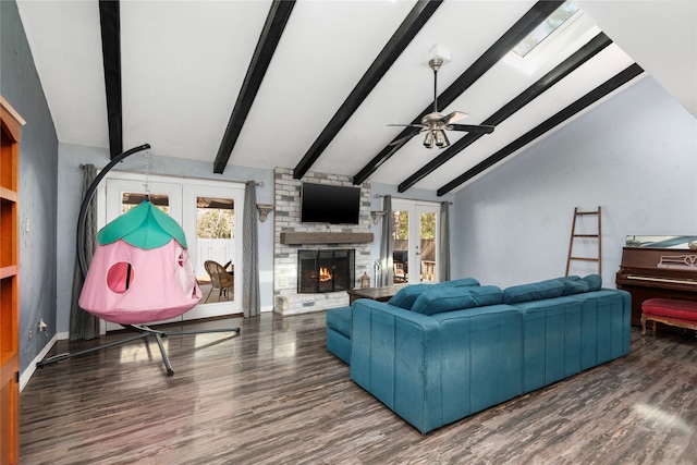 living room featuring french doors, vaulted ceiling with skylight, and plenty of natural light