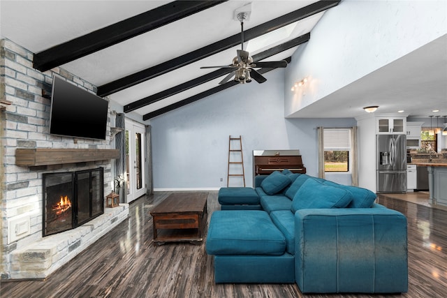 living room with ceiling fan, dark hardwood / wood-style floors, a fireplace, lofted ceiling with beams, and sink