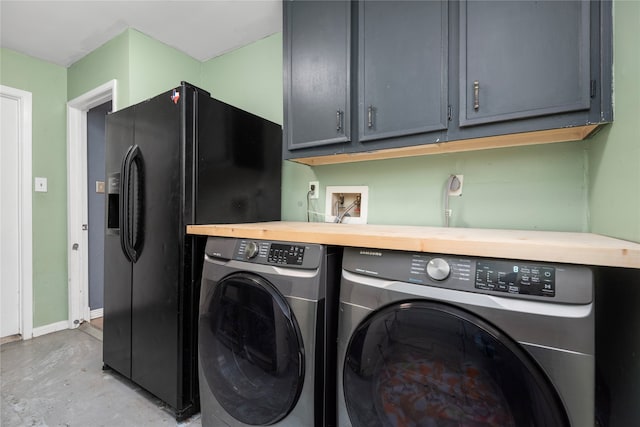 laundry area with separate washer and dryer and cabinets