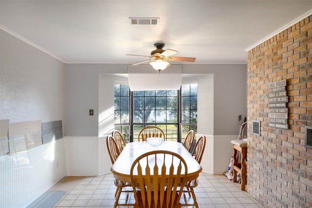 dining area featuring ceiling fan, ornamental molding, and light tile patterned floors