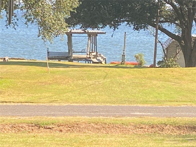 view of community with a yard and a water view