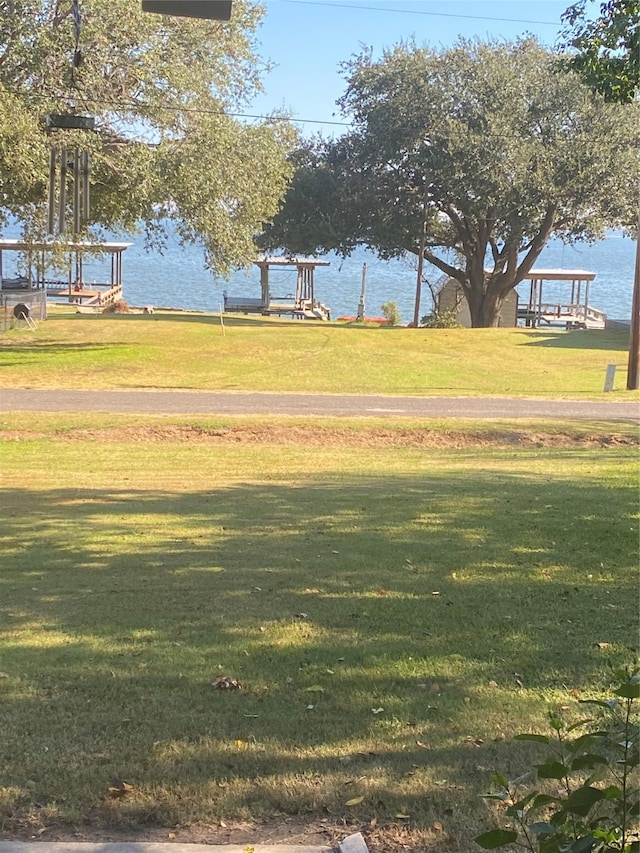 view of community featuring a lawn and a water view