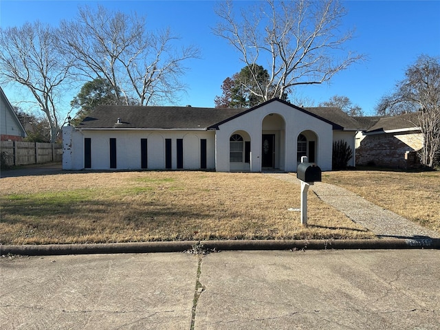 view of front of property with fence, a front lawn, and brick siding