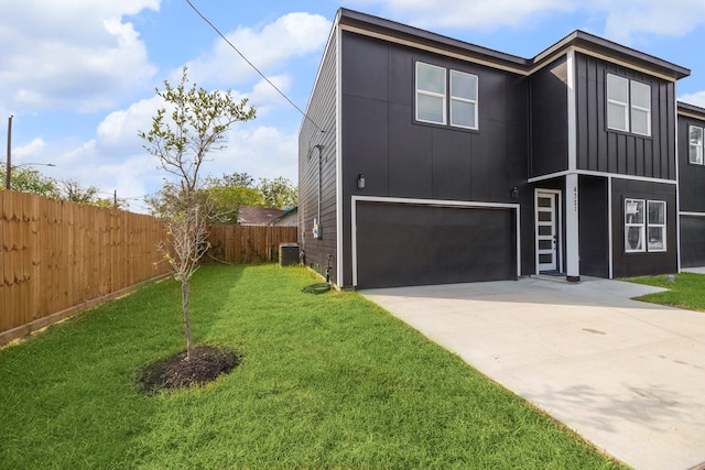 view of front of property with a garage, central air condition unit, and a front yard