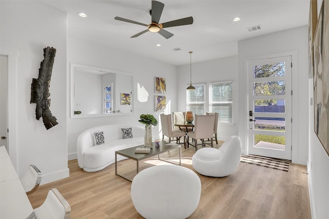 living area with light wood-type flooring and ceiling fan